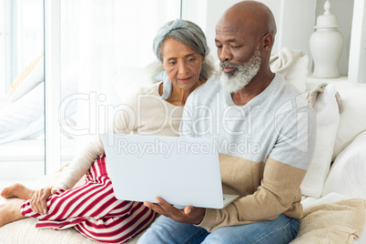Couple using a white laptop