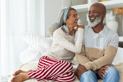 Couple smiling while sitting in a white room