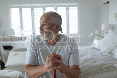 Man sitting on the bed while looking out the window