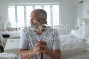 Man sitting on the bed while looking out the window