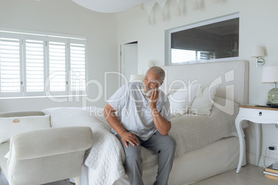 Man sitting on the bed inside white room