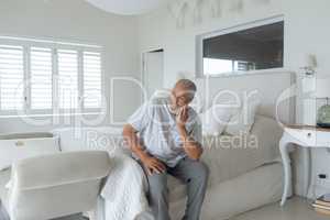 Man sitting on the bed inside white room