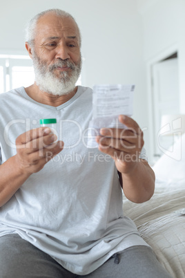 Man sitting on the bed while reading through the prescription