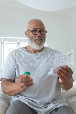 Man wearing glasses while sitting on bed