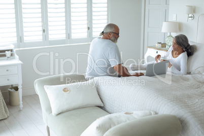 Couple sitting on the bed inside a room