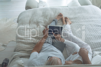 Couple lying in bed and watching digital tablet