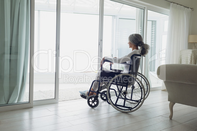 Woman on wheelchair looking outside