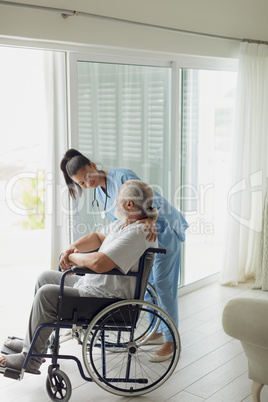Healthcare worker talking with man on wheelchair