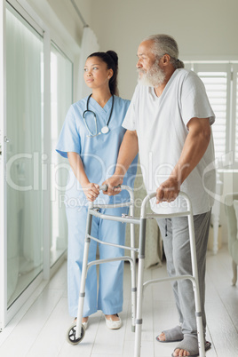 Healthcare worker with man using walking support