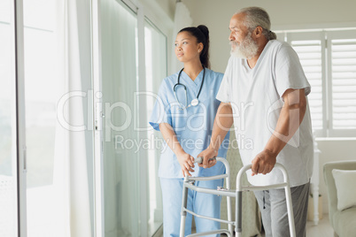 Healthcare worker with man using walking support