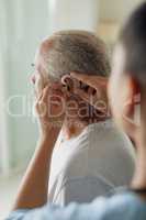 Healthcare worker putting hearing aid