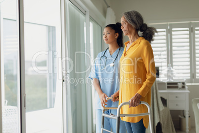 Healthcare worker and woman using walking aid