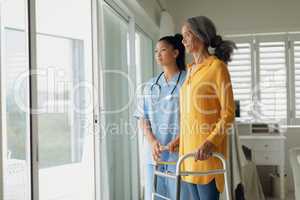 Healthcare worker and woman using walking aid
