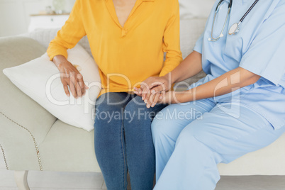 Healthcare worker and woman sitting on a couch