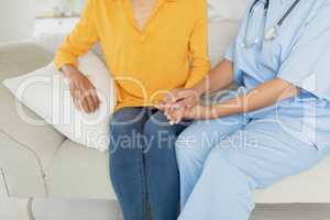Healthcare worker and woman sitting on a couch