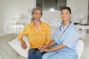 Healthcare worker and woman sitting on couch
