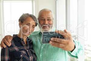 Couple taking picture with smartphone inside a room