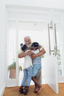 Man with grandchildren by the door