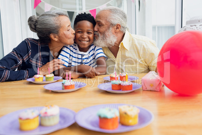 Grandparents kissing grandson