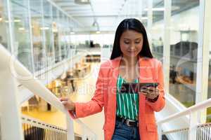 Businesswoman using digital tablet while walking on stairs