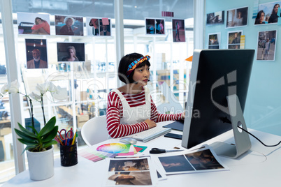 Female Graphic designer using graphic tablet at desk