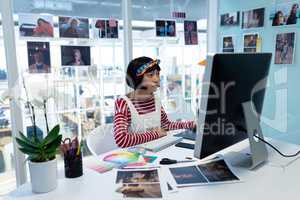 Female Graphic designer using graphic tablet at desk