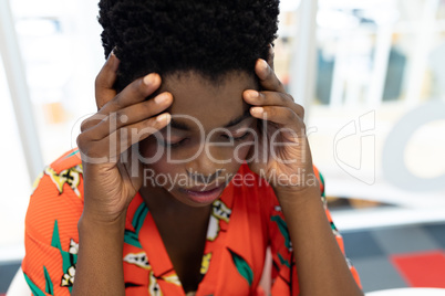 Stressed female graphic designer sitting at desk