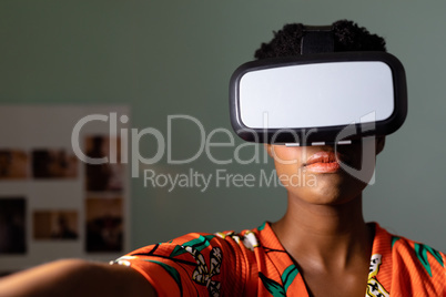 Female graphic designer using virtual reality headset in office