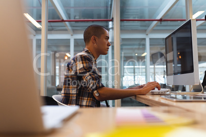 Male graphic designer working on computer at desk