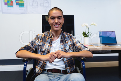 Disabled male executive smiling at desk in office