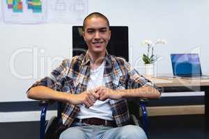 Disabled male executive smiling at desk in office