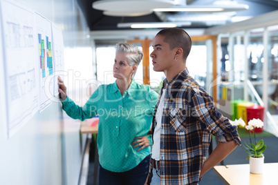 Male and female architects looking at an architectural plan in office