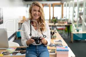 Female graphic designer reviewing photos on digital camera