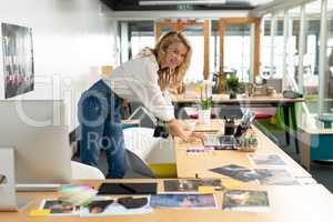Female graphic designer using laptop at desk
