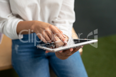 Female graphic designer using digital tablet at desk