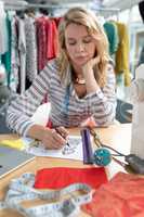 Female fashion designer drawing sketch on a table