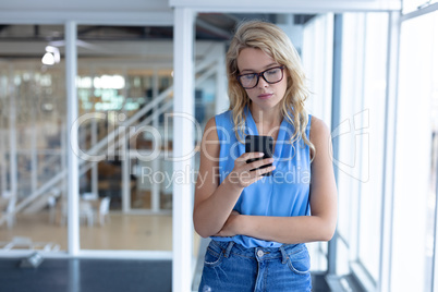 Beautiful businesswoman using mobile phone in a modern office