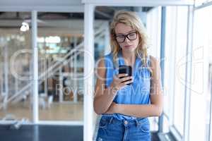 Beautiful businesswoman using mobile phone in a modern office