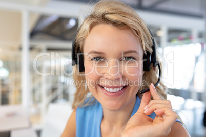 Female customer service executive talking on headset at desk in office