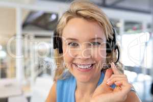 Female customer service executive talking on headset at desk in office