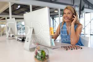 Female customer service executive talking on headset at desk