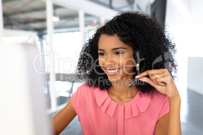 Female customer service executive talking on headset at desk