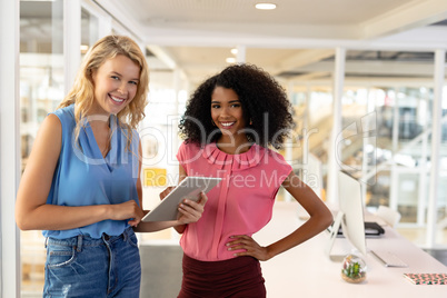 Female executives discussing over digital tablet in office