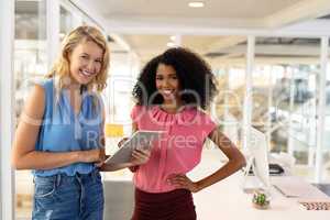 Female executives discussing over digital tablet in office