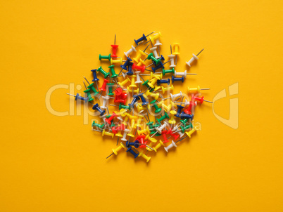 Colorful pushpins on yellow