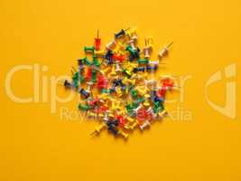 Colorful pushpins on yellow