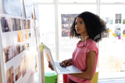 Female graphic designer using laptop in office