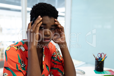 Stressed female graphic designer sitting at desk