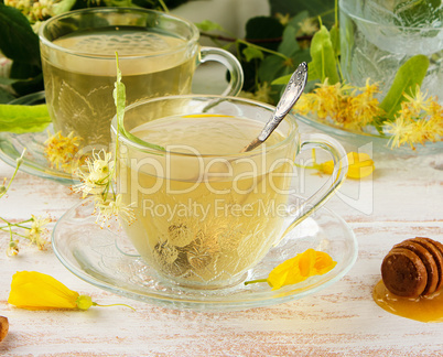 transparent cup with tea from linden on a white wooden board