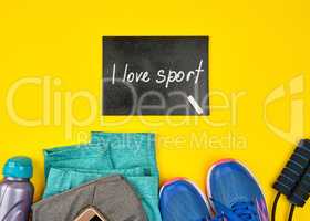 empty blackboard and blue women's sneakers and clothes for sport